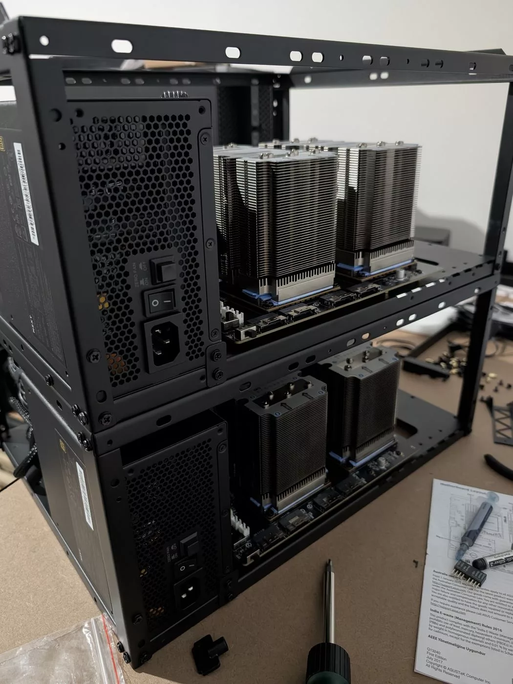 Two stacked frame tiers, each holding a carrier with two heatsinks and its own power supply